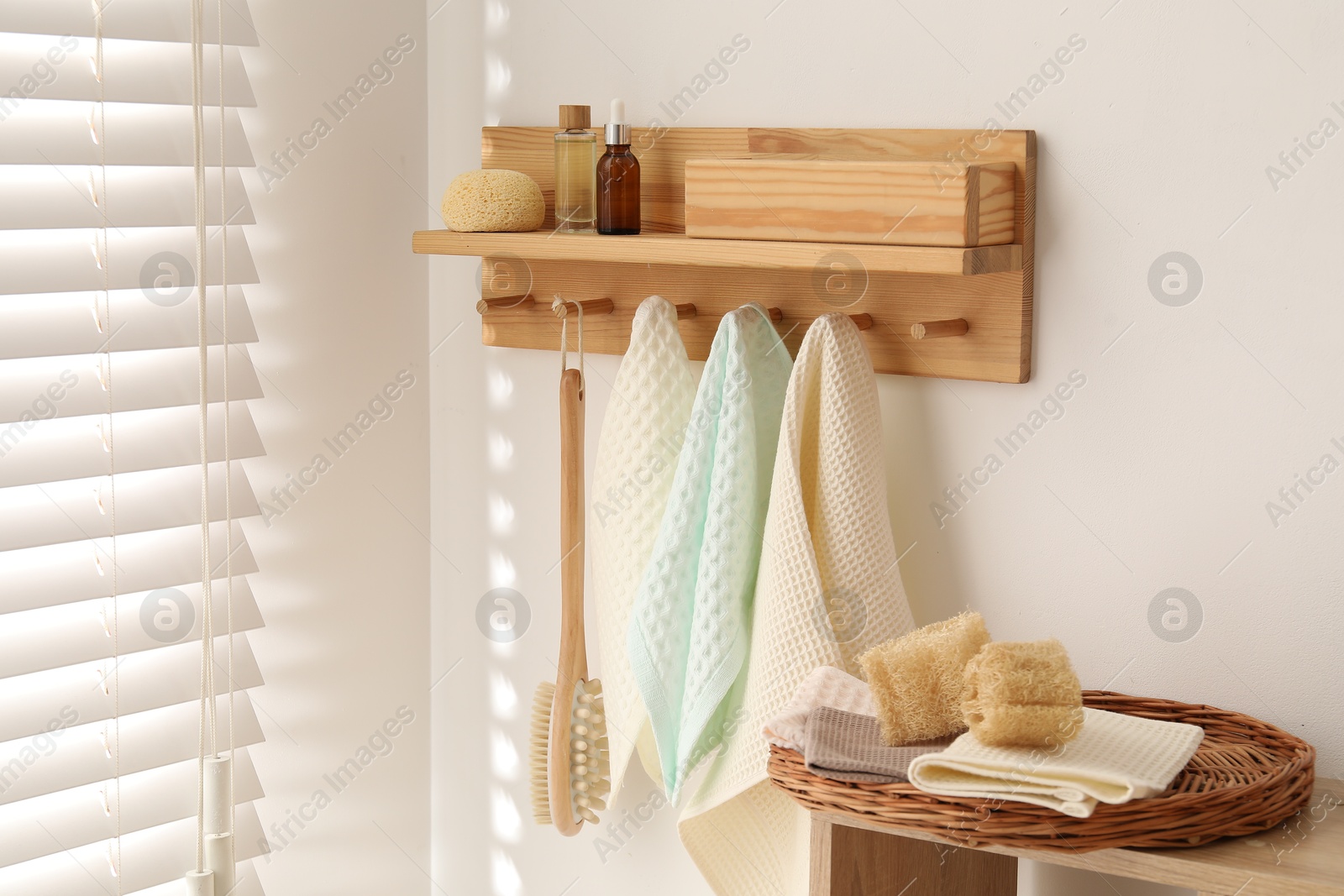 Photo of Clean waffle towels and brush hanging on hook rack in bathroom