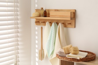 Photo of Clean waffle towels and brush hanging on hook rack in bathroom
