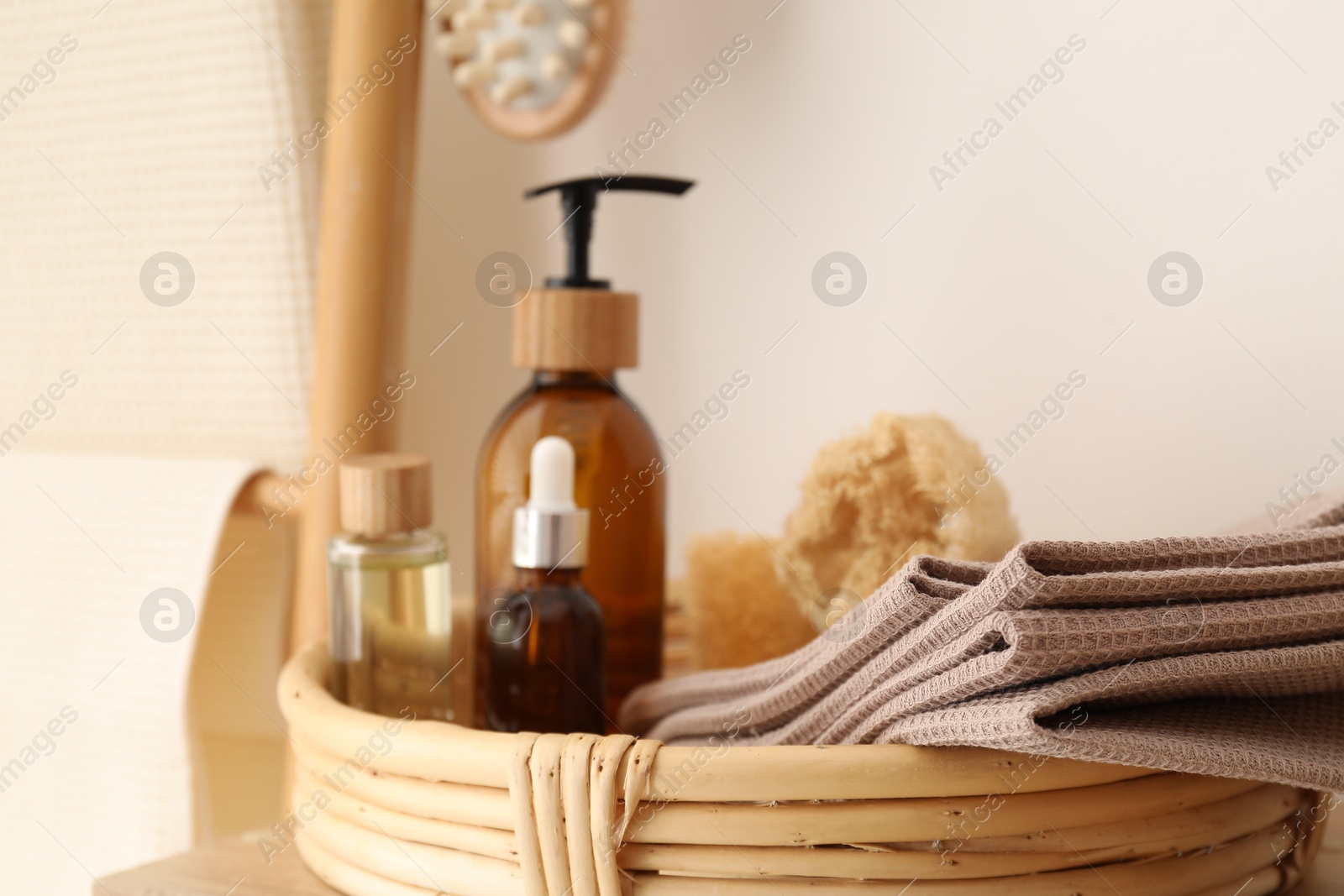 Photo of Clean waffle towels and spa products near white wall, closeup