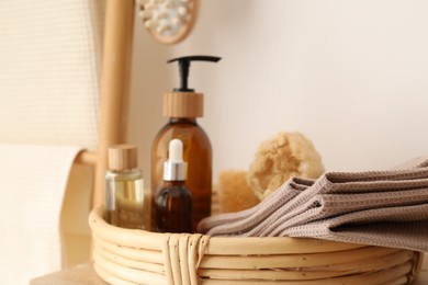 Photo of Clean waffle towels and spa products near white wall, closeup