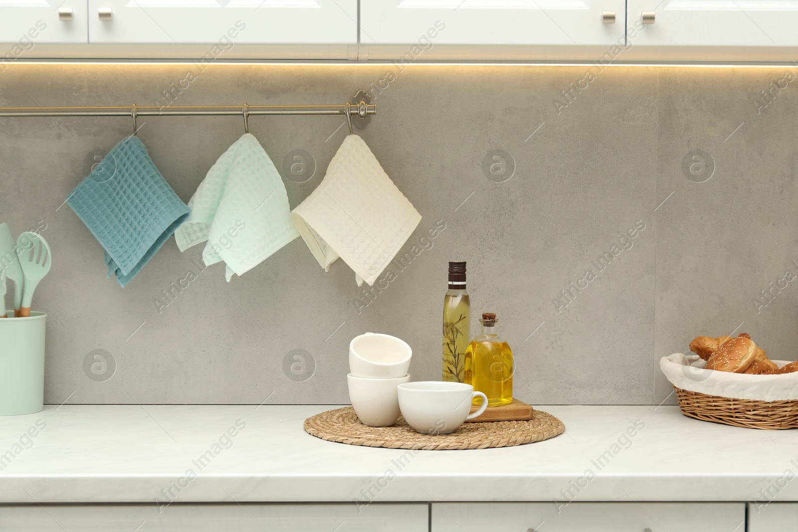 Photo of Clean waffle towels hanging on hook rack in kitchen