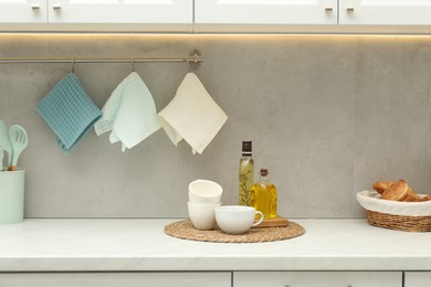 Photo of Clean waffle towels hanging on hook rack in kitchen