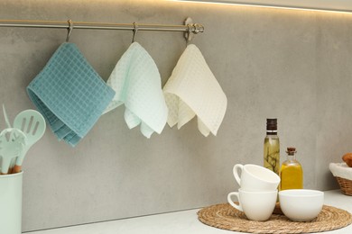 Photo of Clean waffle towels hanging on hook rack in kitchen