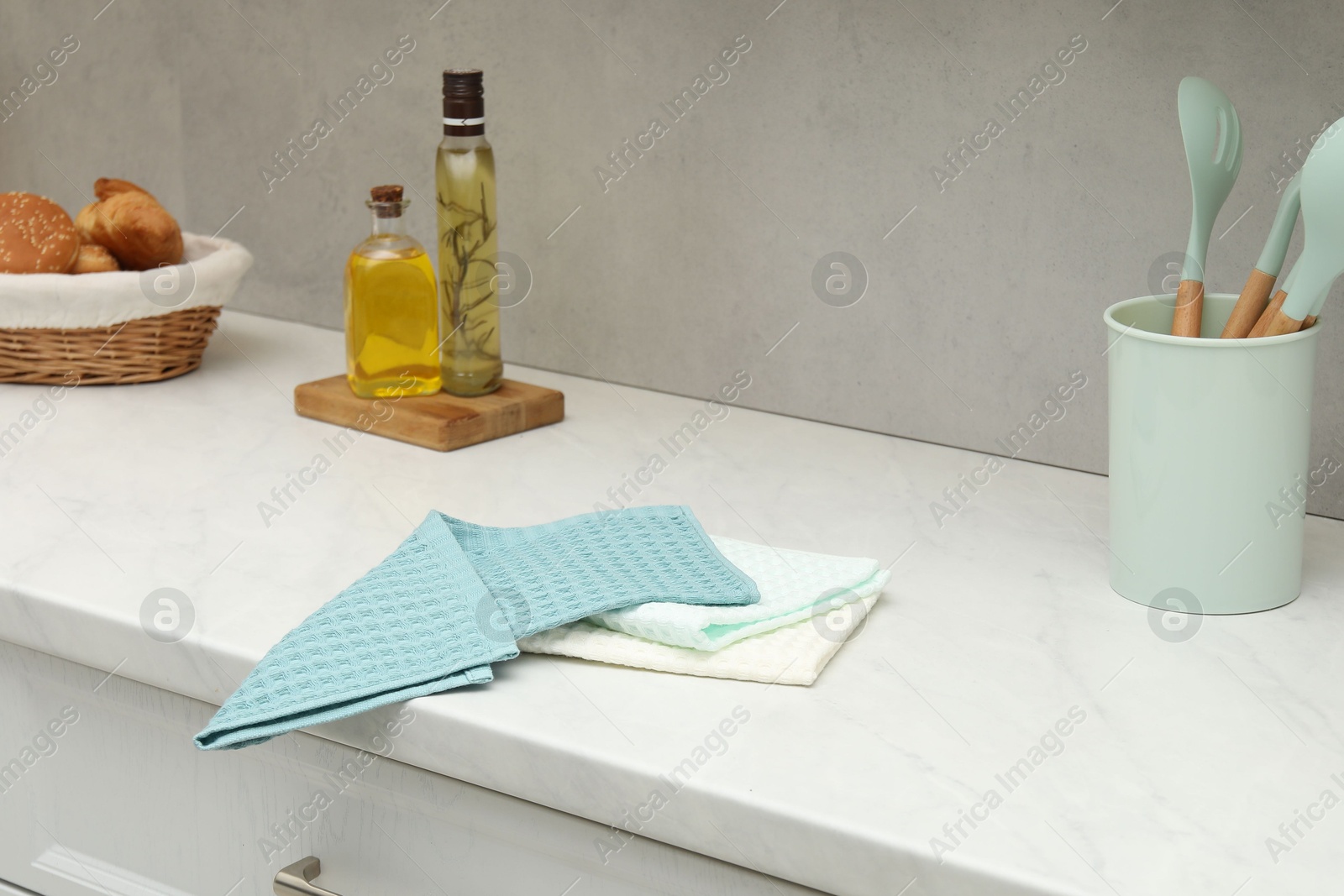 Photo of Waffle towels and kitchenware on white counter near grey wall
