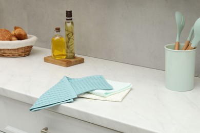 Photo of Waffle towels and kitchenware on white counter near grey wall