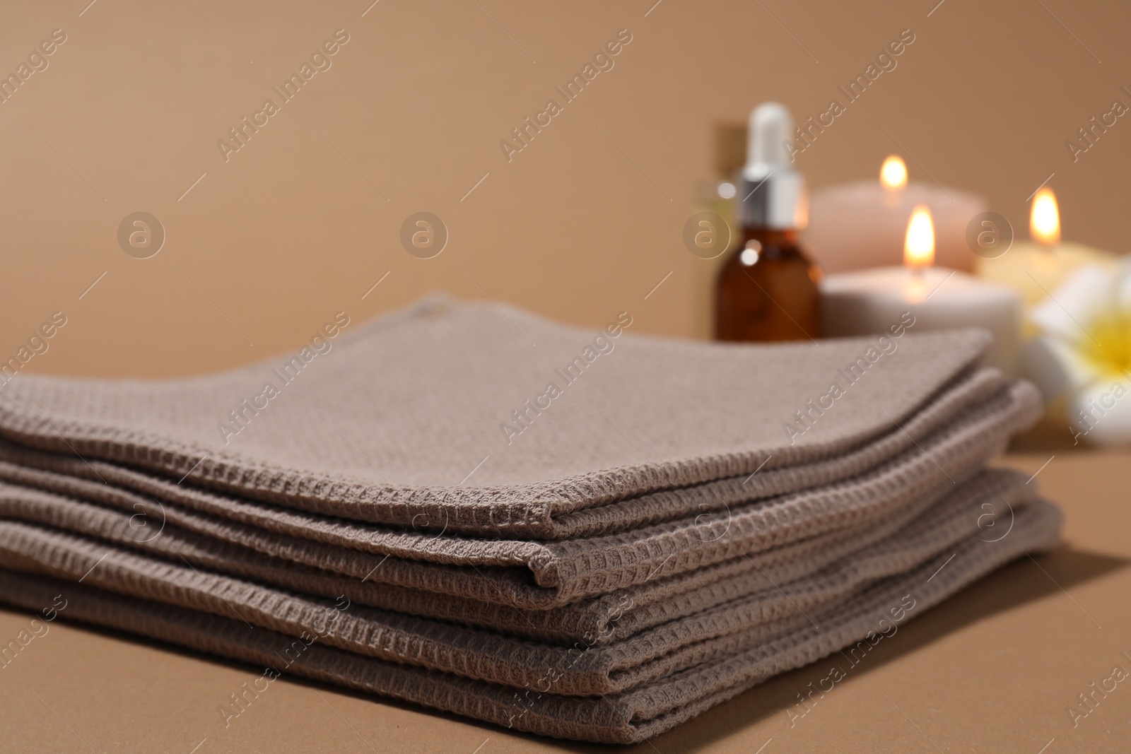 Photo of Stack of folded waffle towels on light brown background, closeup