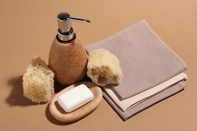 Photo of Folded waffle towels and spa products on light brown background, closeup