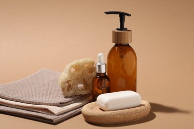 Photo of Folded waffle towels and spa products on light brown background, closeup