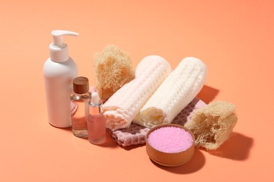 Photo of Clean waffle towels and spa products on coral background, closeup