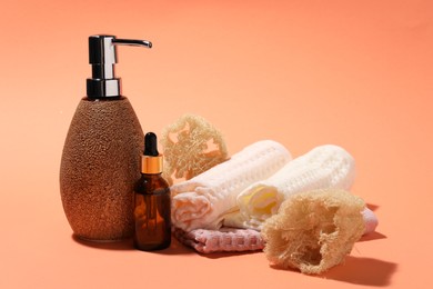 Photo of Clean waffle towels and spa products on coral background, closeup