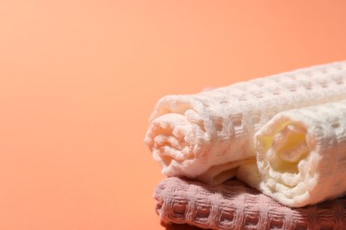 Photo of Clean waffle towels on coral background, closeup. Space for text