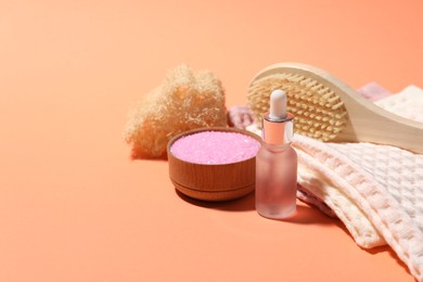 Photo of Clean waffle towels and spa products on coral background, closeup