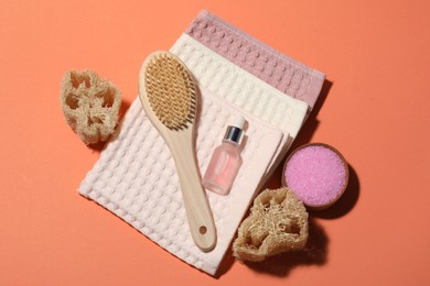 Photo of Clean waffle towels and spa products on coral background, flat lay