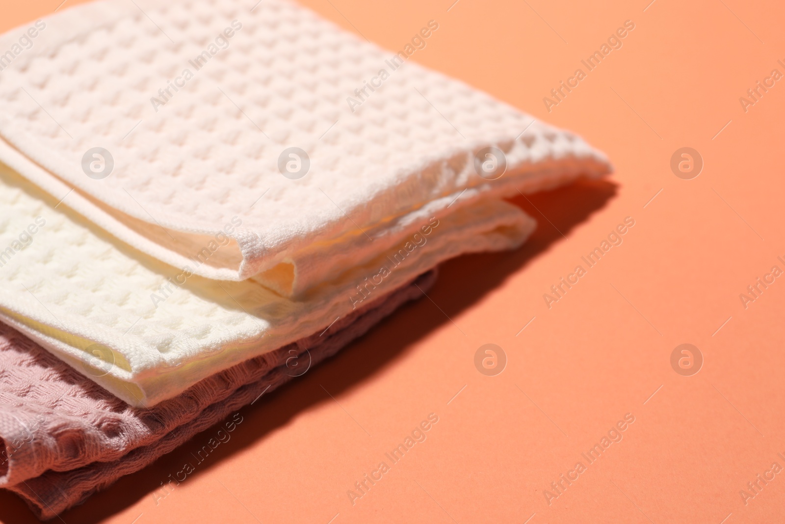 Photo of Clean waffle towels on coral background, closeup