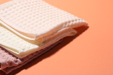 Photo of Clean waffle towels on coral background, closeup