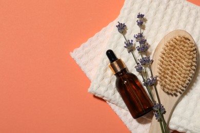 Photo of Clean waffle towels, lavender plant, dropper and brush on coral background, flat lay. Space for text