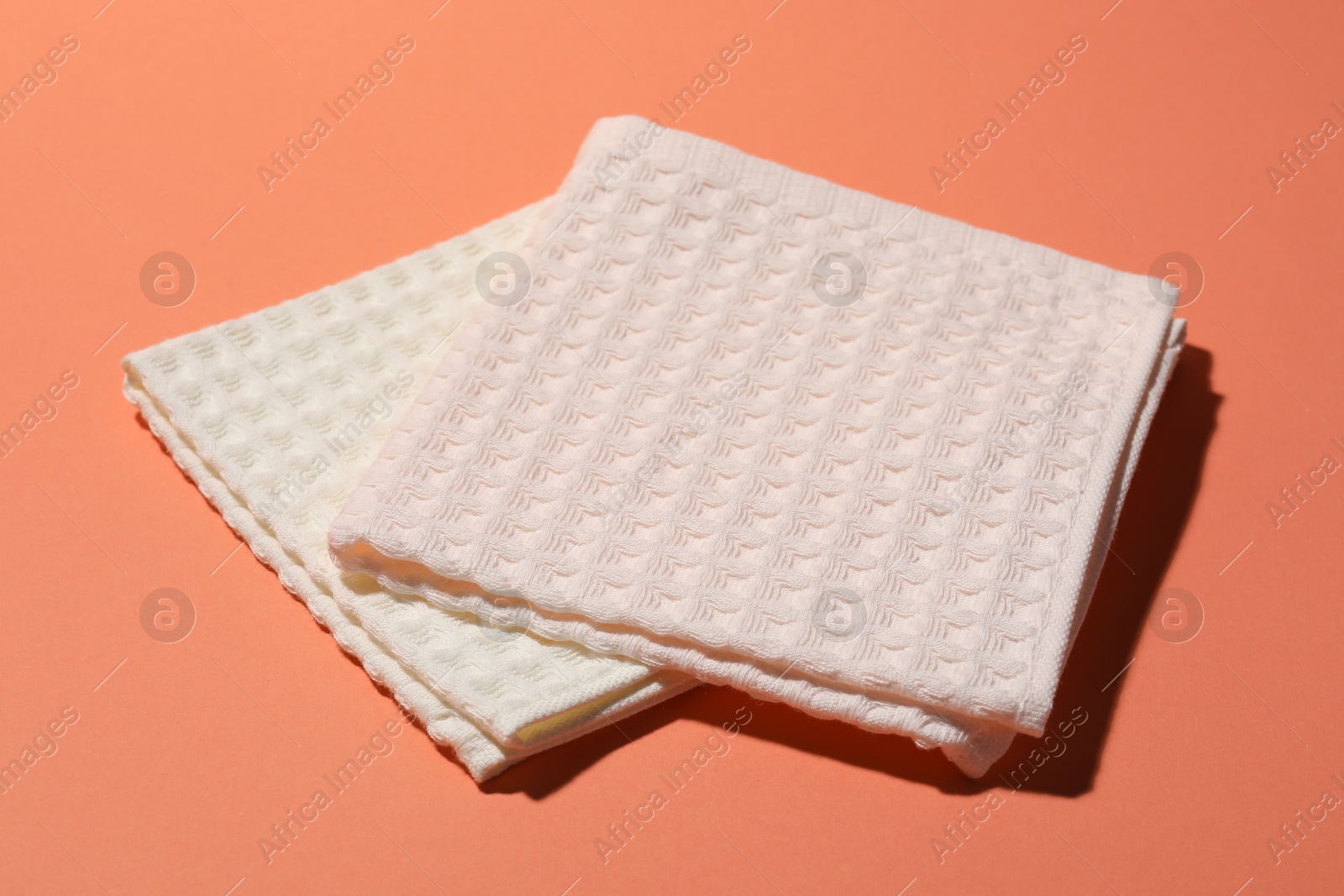Photo of Clean waffle towels on coral background, closeup