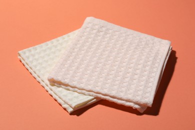 Photo of Clean waffle towels on coral background, closeup