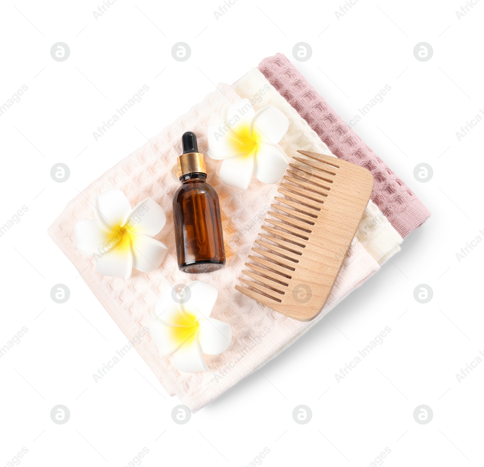 Photo of Clean waffle towels, plumeria flowers, dropper and comb isolated on white, top view