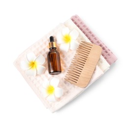 Photo of Clean waffle towels, plumeria flowers, dropper and comb isolated on white, top view