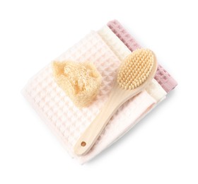 Photo of Clean waffle towels, brush and loofah isolated on white, top view