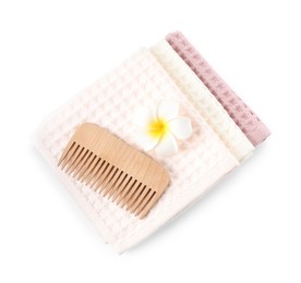 Photo of Clean waffle towels, plumeria flower and comb isolated on white, top view