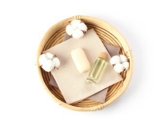 Photo of Clean waffle towels, cotton flowers and spa products in wicker basket isolated on white, top view