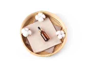 Photo of Clean waffle towels, cotton flowers and dropper in wicker basket isolated on white, top view