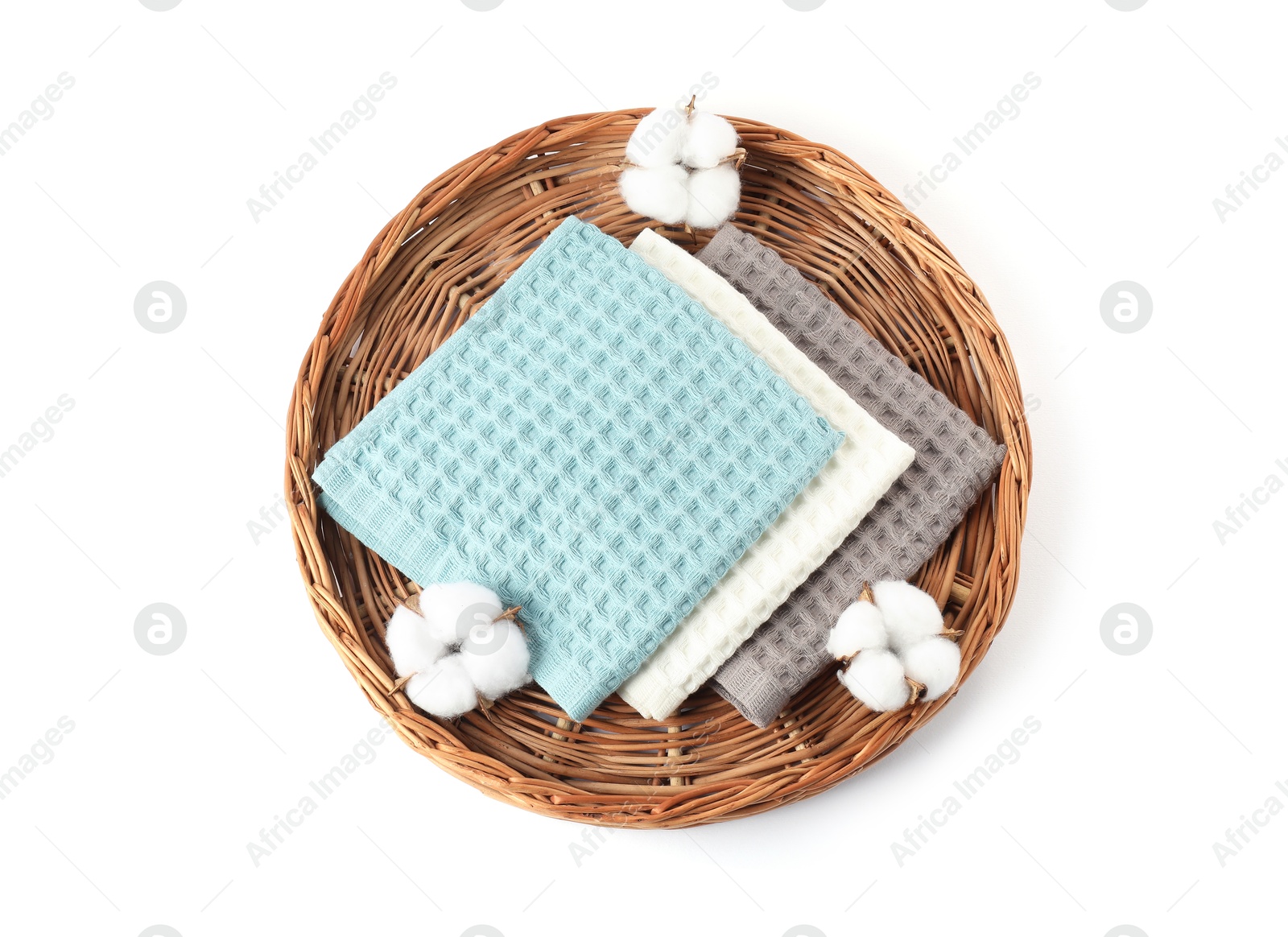 Photo of Clean waffle towels and cotton flowers on wicker surface isolated on white, top view