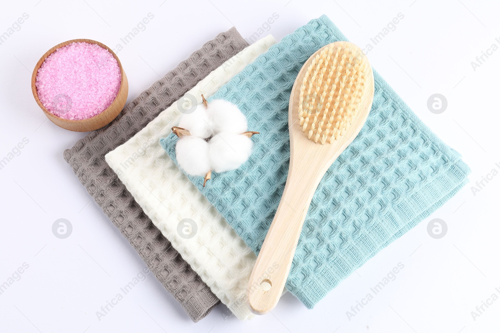 Photo of Clean waffle towels, cotton flower and spa products on white background, flat lay