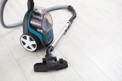 Photo of One vacuum cleaner on wooden floor. Household appliance