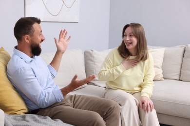 Photo of Friends laughing on sofa at home. Positive emotion
