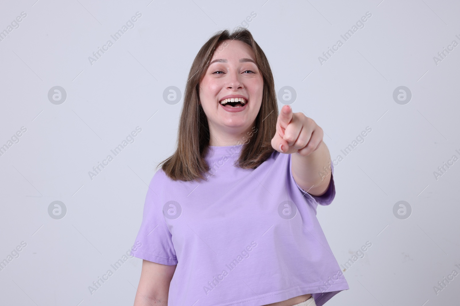 Photo of Attractive woman laughing on grey background. Positive emotion