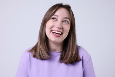 Photo of Attractive woman laughing on grey background. Positive emotion