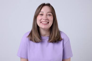 Photo of Attractive woman laughing on grey background. Positive emotion