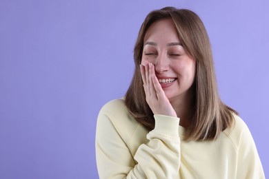 Photo of Attractive woman laughing on violet background. Space for text