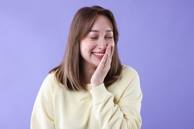 Photo of Attractive woman laughing on violet background. Positive emotion