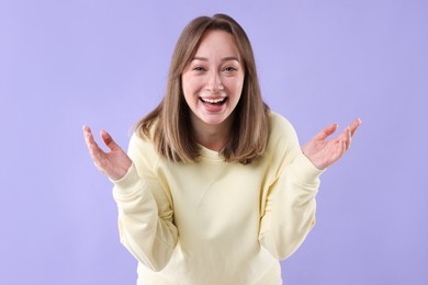 Photo of Attractive woman laughing on violet background. Positive emotion