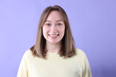 Photo of Attractive woman laughing on violet background. Positive emotion