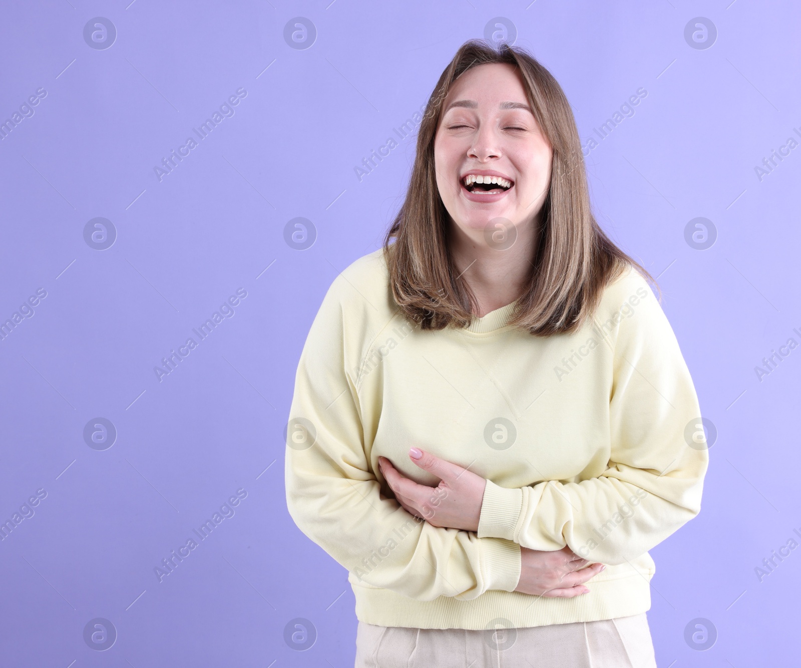 Photo of Attractive woman laughing on violet background. Positive emotion
