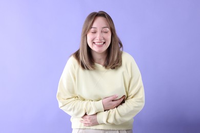 Photo of Attractive woman laughing on violet background. Positive emotion