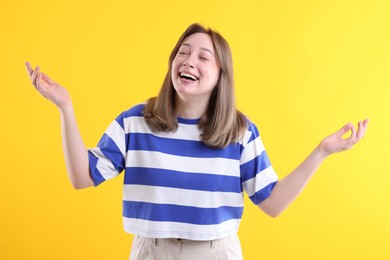Photo of Attractive woman laughing on yellow background. Positive emotion