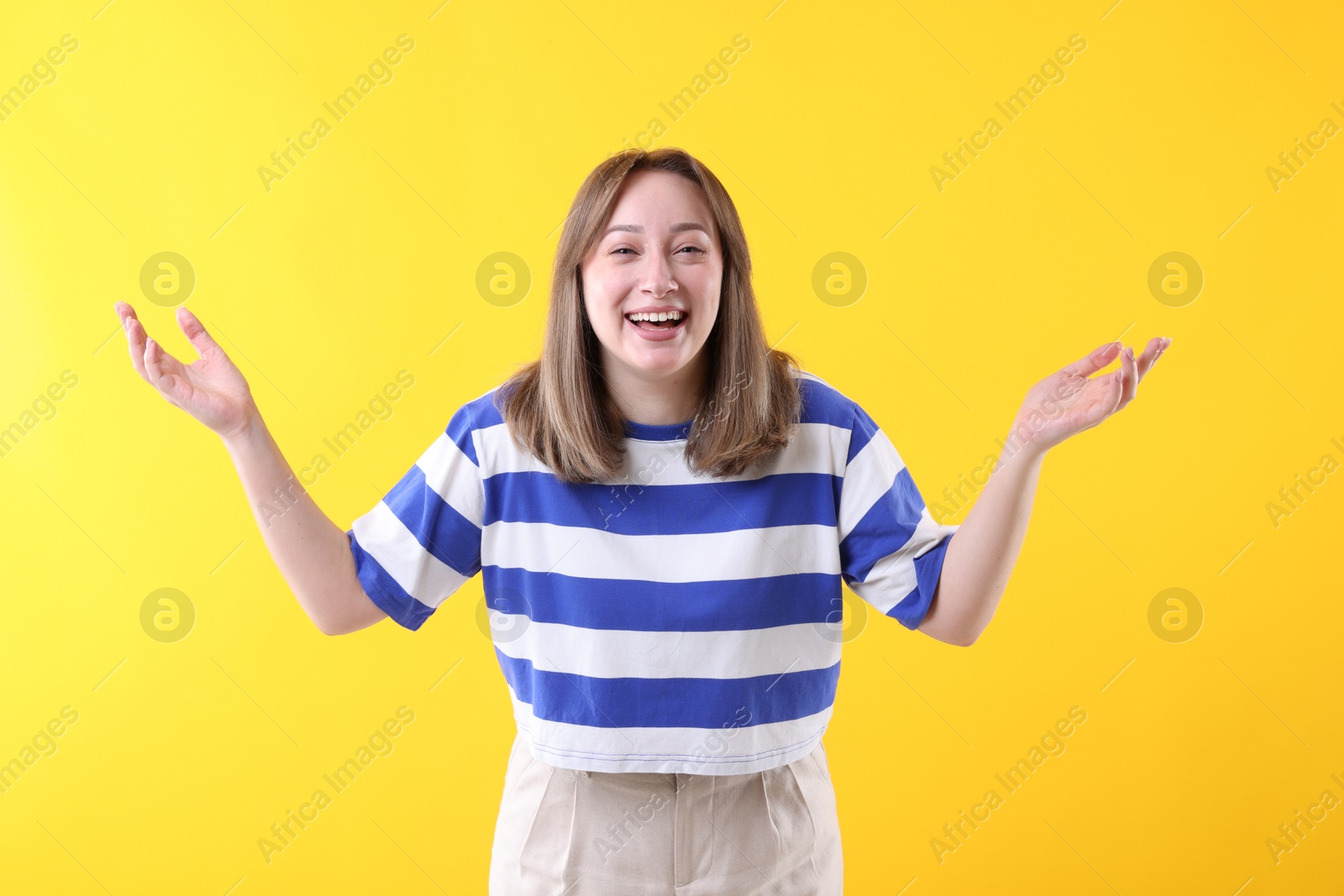 Photo of Attractive woman laughing on yellow background. Positive emotion