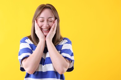 Photo of Attractive woman laughing on yellow background. Space for text