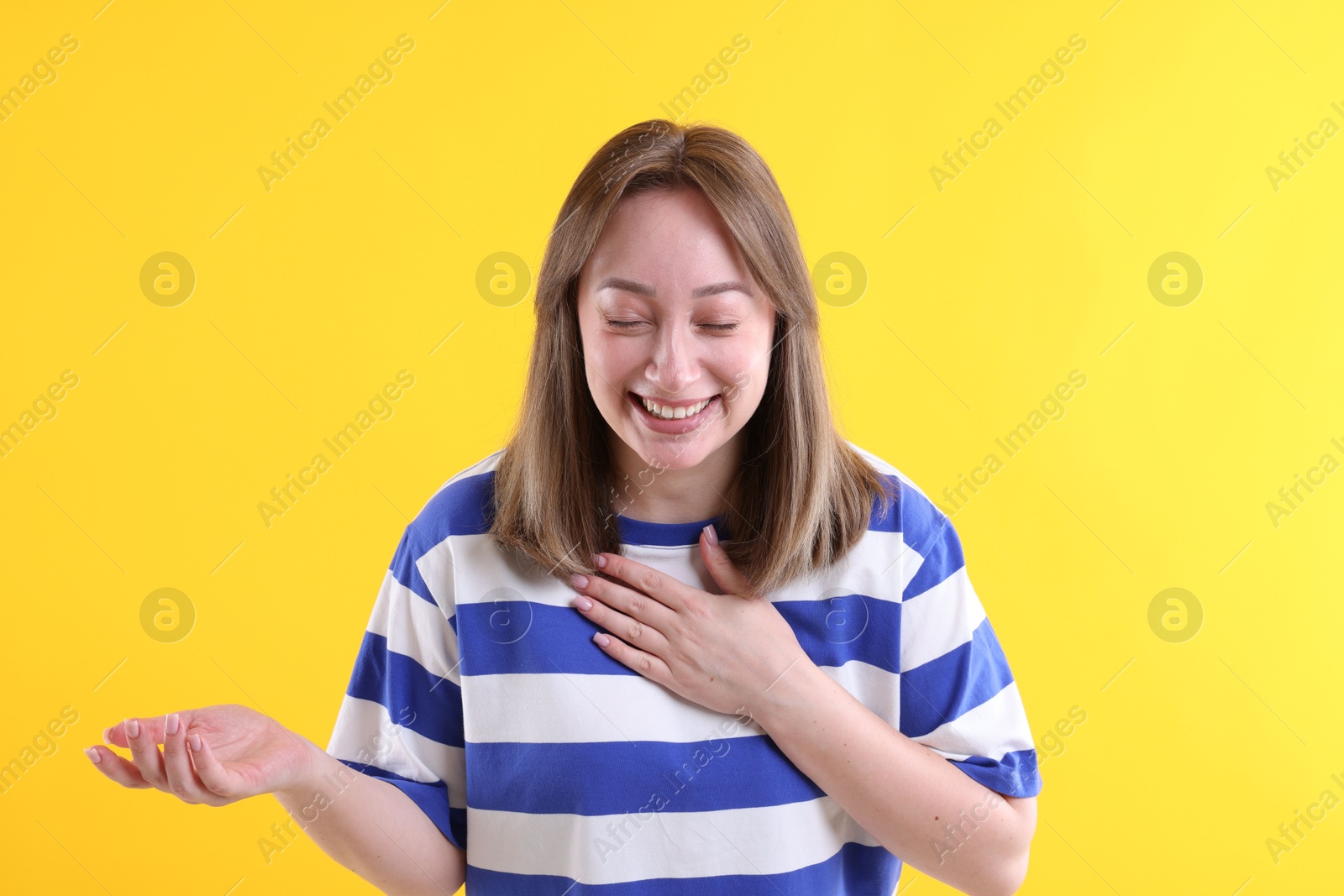 Photo of Attractive woman laughing on yellow background. Positive emotion