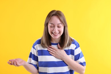 Photo of Attractive woman laughing on yellow background. Positive emotion