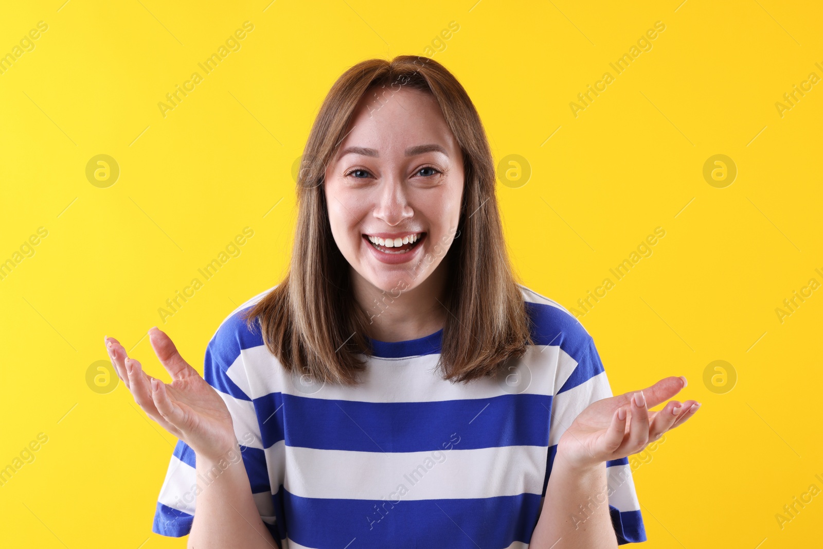 Photo of Attractive woman laughing on yellow background. Positive emotion