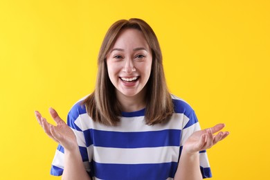 Photo of Attractive woman laughing on yellow background. Positive emotion