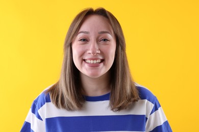 Photo of Attractive woman laughing on yellow background. Positive emotion