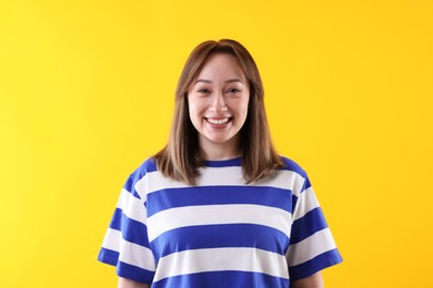 Photo of Attractive woman laughing on yellow background. Positive emotion